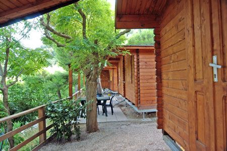 Un portico di cabine di legno con mobili da esterno.