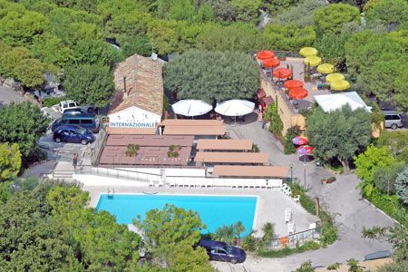 Vista aerea di un'area con piscina, edifici e alberi.