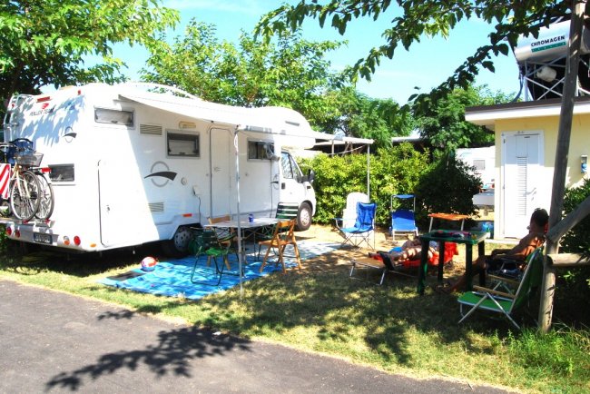 Camper con sedie e tavolo all'aperto.