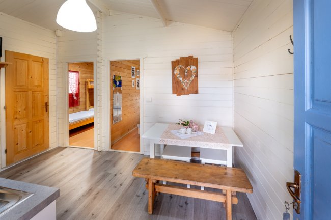 Interno di una casa in legno, tavolo e panche.