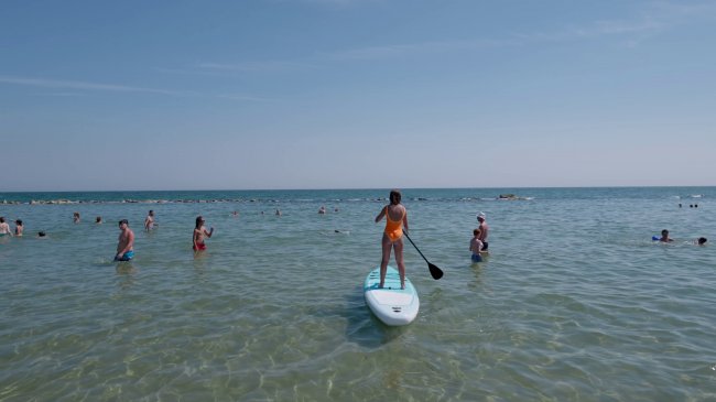 Persone in mare, paddleboard al centro.