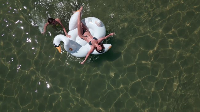 Persona su un gonfiabile a forma di cigno in mare.