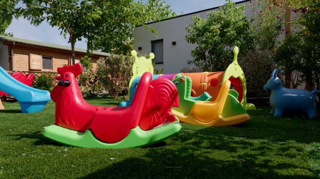 Giardino giochi con altalene colorate.