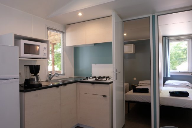 Cucina moderna con microonde e vista su due stanze.