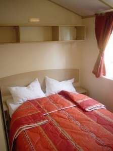 Camera da letto con letto matrimoniale e copriletto rosso.