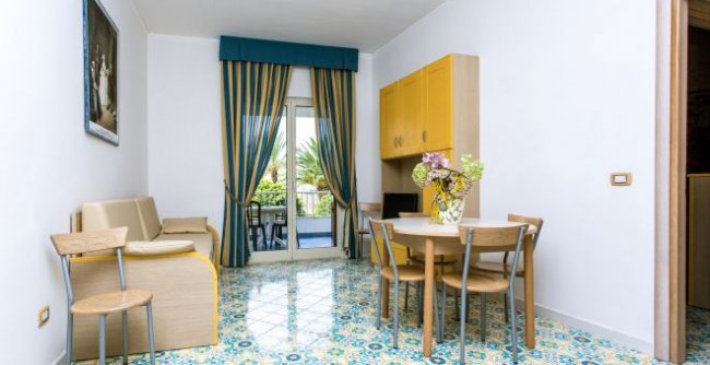 Sala da pranzo con tavolo rotondo e tende blu.