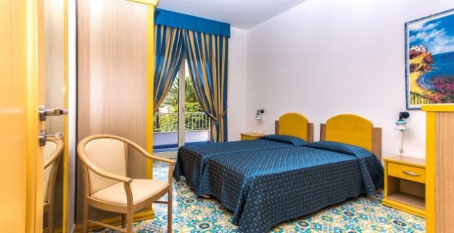 Camera da letto con tende a righe blu e mobili gialli.