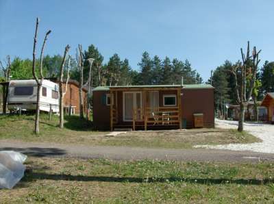 Casa mobile marrone con veranda, vicina a una roulotte.