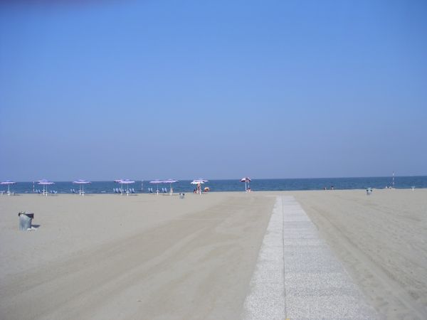 Spiaggia con ombrelloni e mare.