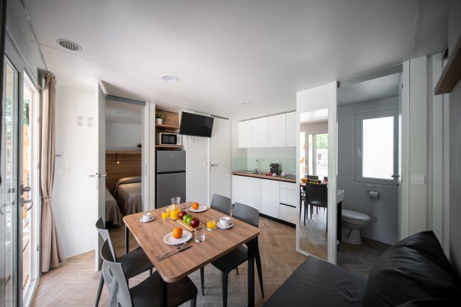 Cucina moderna con tavolo apparecchiato e frutta fresca.