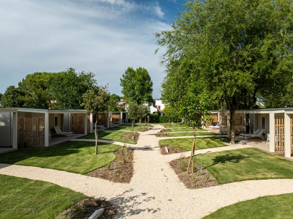 Bungalows con vialetti in giardino.