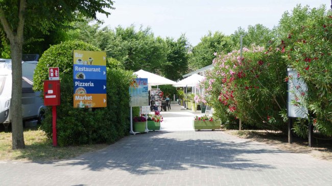 Ingresso con cartelli per bar, ristorante e pizzeria.