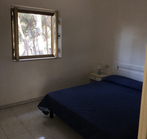 Una camera con letto matrimoniale e finestra aperta.