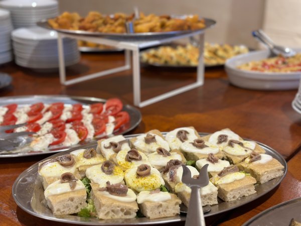 Piatto di antipasti con pane, formaggio e acciughe.