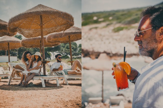 Due persone sotto ombrelloni sulla spiaggia e bevanda con fetta d'arancia.